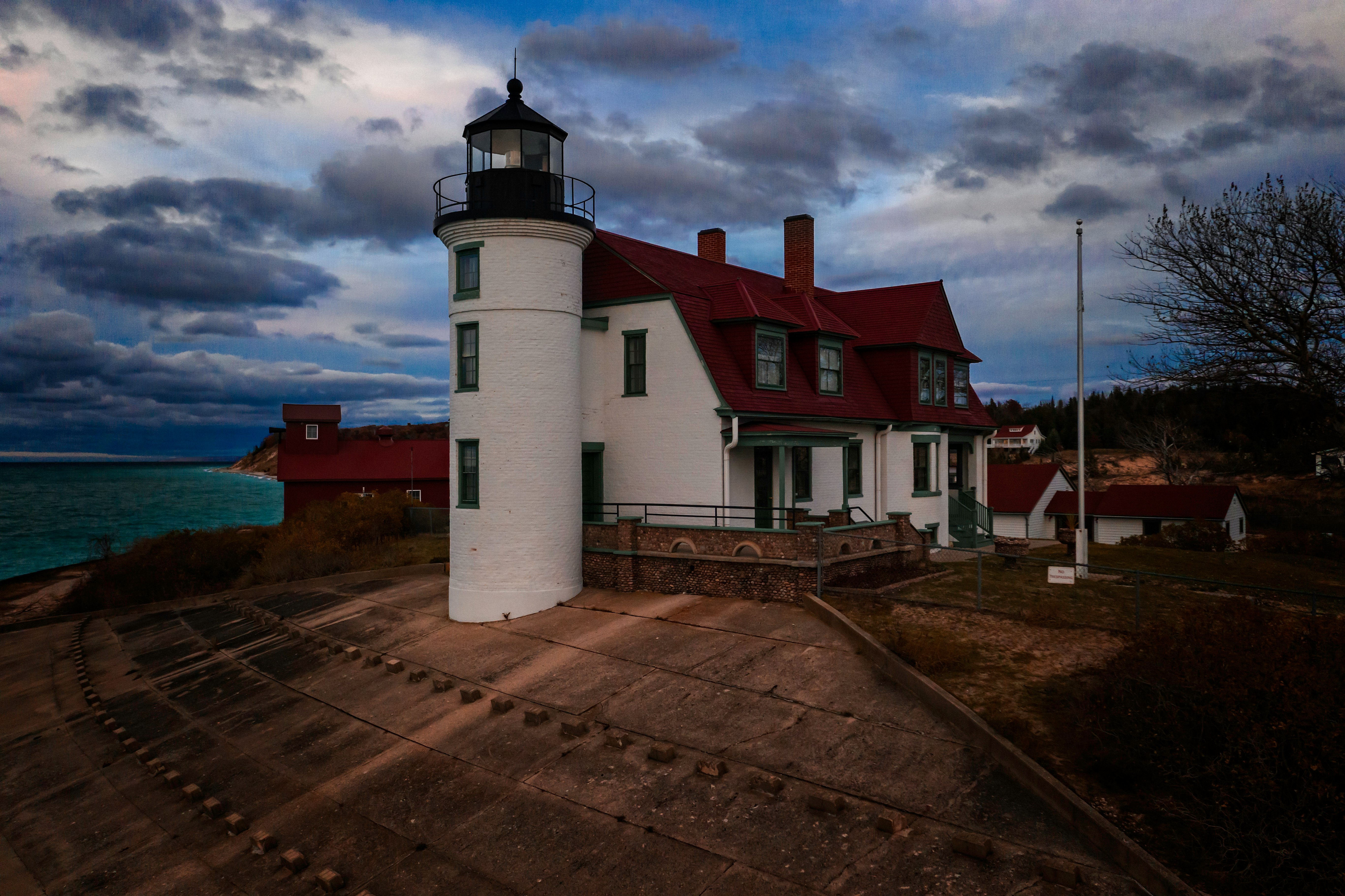 lighthouse and house near the ocean during day